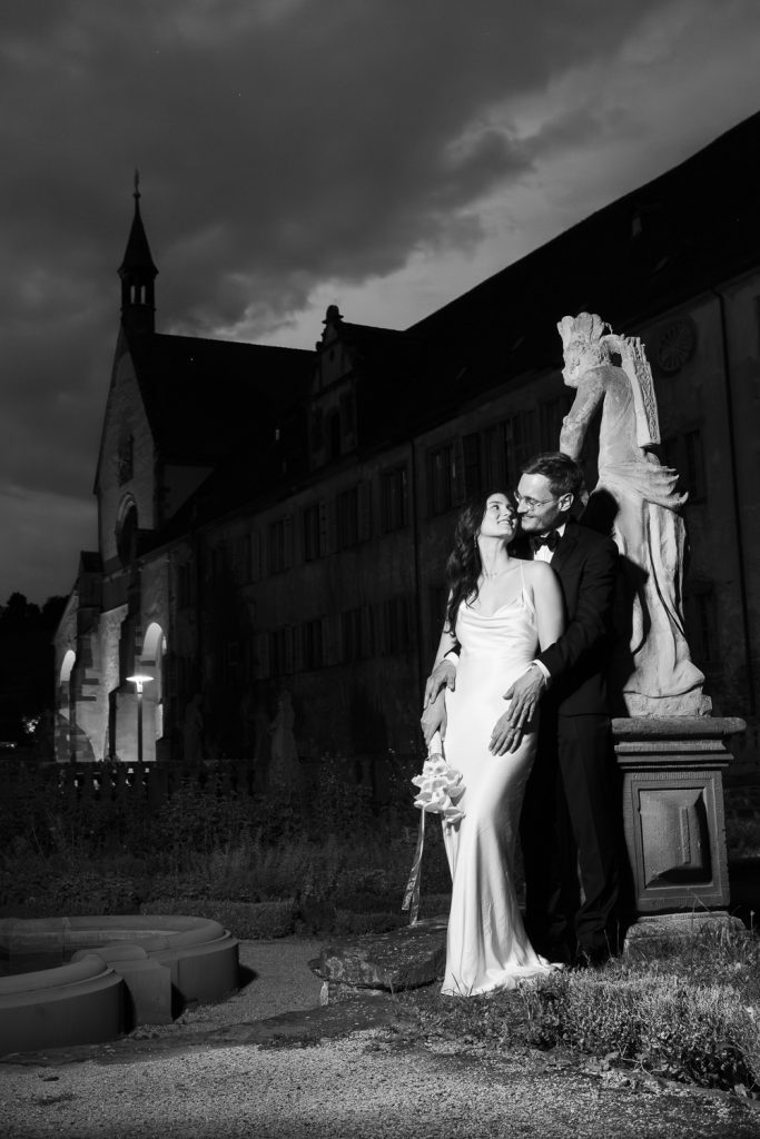 Hochzeitspaar in einem Garten eines barocken Klosters in der Abenddämmerung