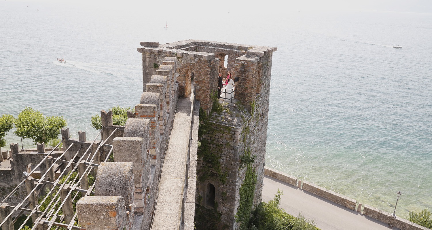 Brautpaar steht auf einem Turm am Gardasee in Italien